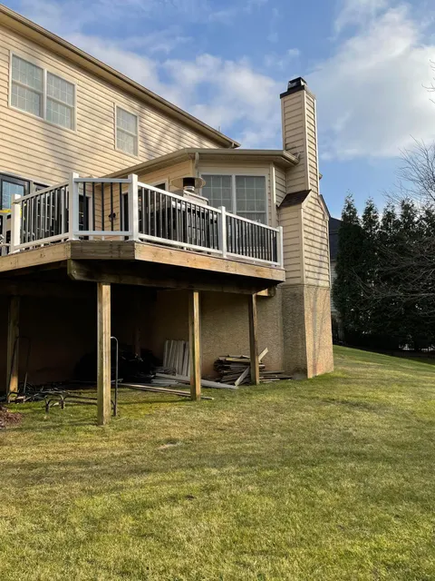 Elevated rear deck with new white vinyl railing and black aluminum balusters