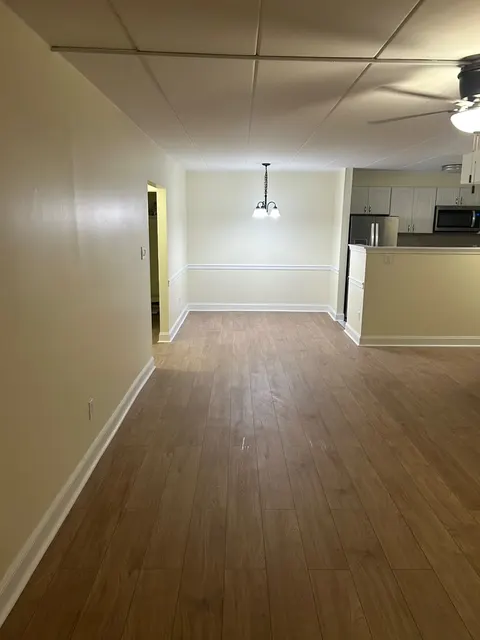 Open living and dining room with new wood-look luxury vinyl plank flooring and fresh white baseboards