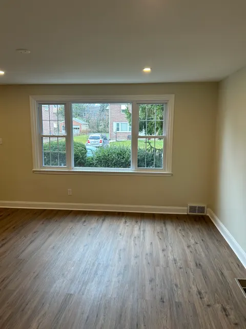 Freshly painted bedroom with new gray-toned luxury vinyl plank flooring and crown molding