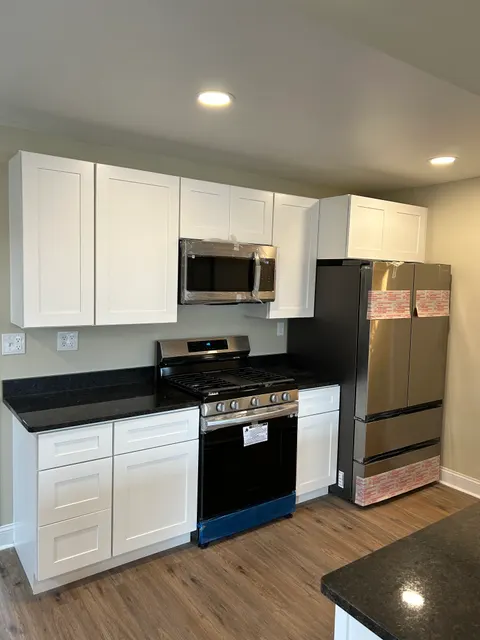 Full kitchen renovation with stainless appliance package, white shaker cabinets, and granite countertops