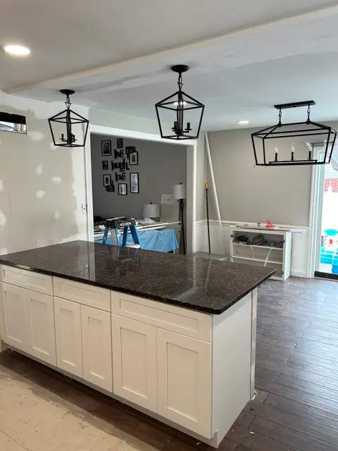 New kitchen cabinets with granite countertop and black lantern pendant lighting