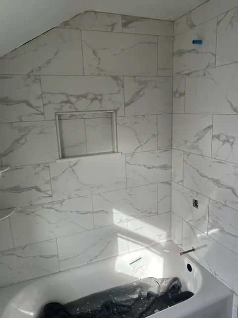 Marble-look tile tub surround with recessed niche during bathroom remodel