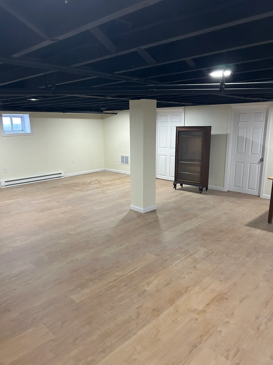 Finished basement living area with wood-look vinyl plank flooring
