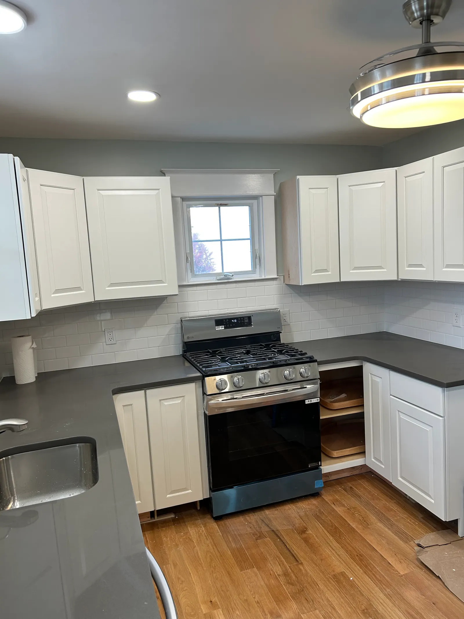 Remodeled kitchen with stainless gas range, white subway tile backsplash, and quartz countertops