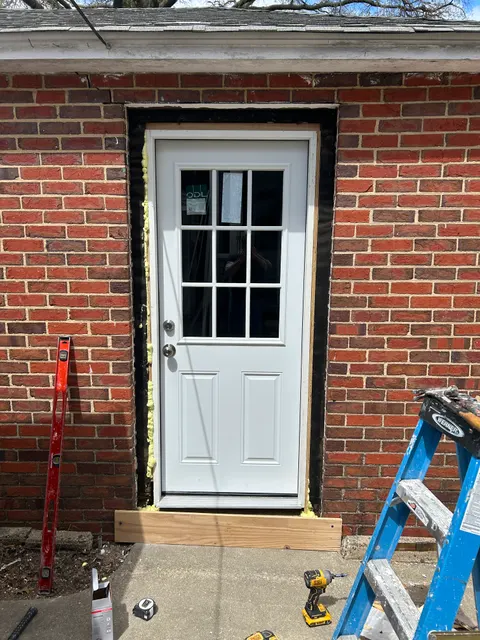 New exterior entry door being installed and flashed into brick side entrance