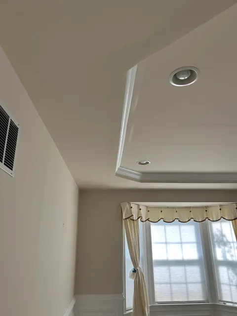 Freshly painted living room with crown molding, glossy white trim, and recessed lighting